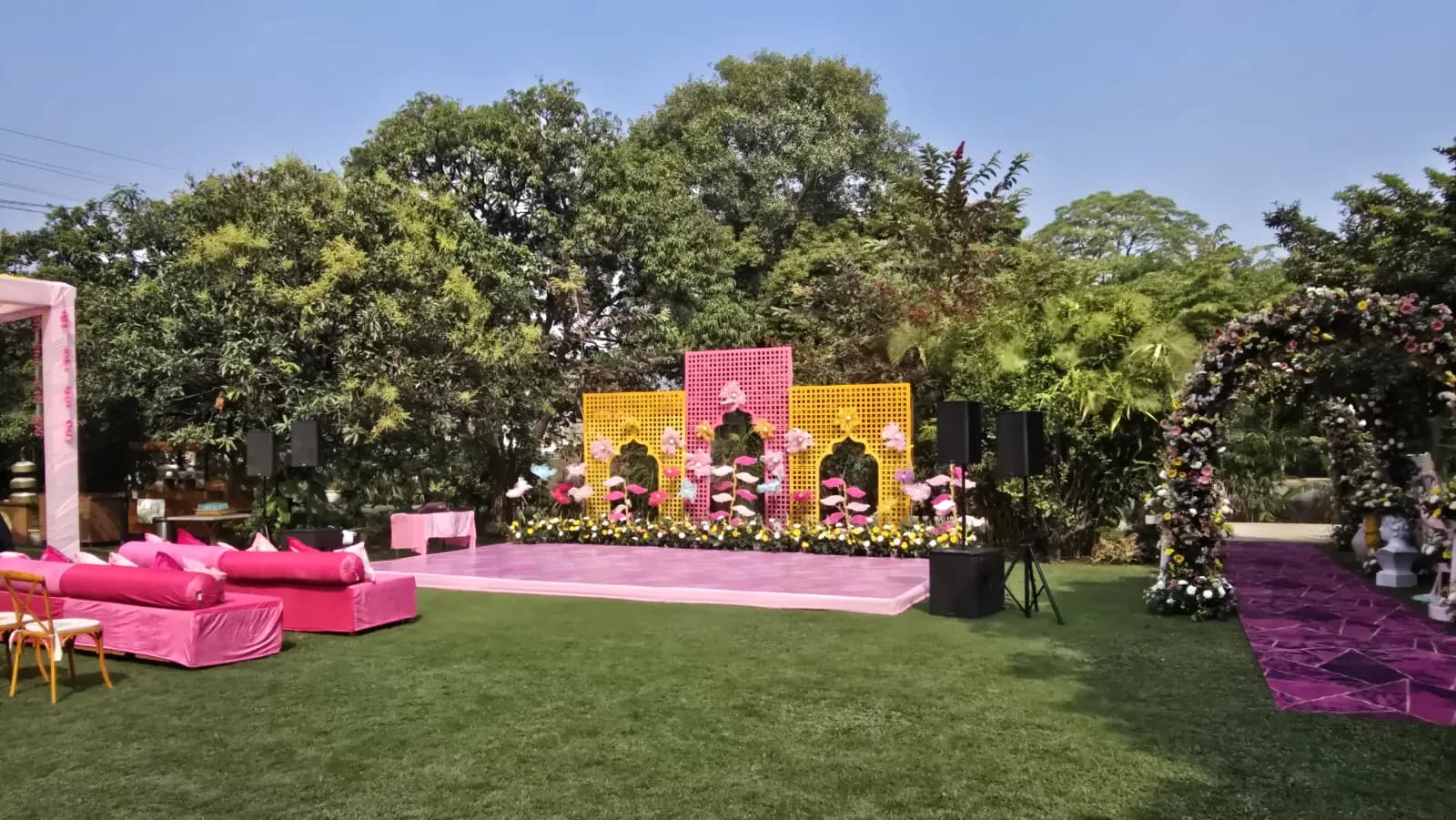 A pink sangeet stage with a floral backdrop